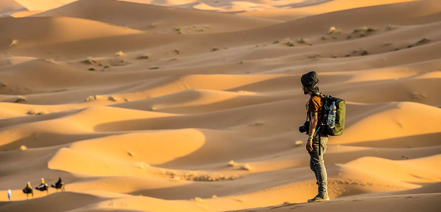 Marokko Adventures Erlebnisreisen Marokko, ein Mann auf einer Düne in der Wüste von Marokko